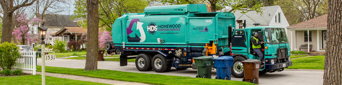 garbage truck on street with recycle can