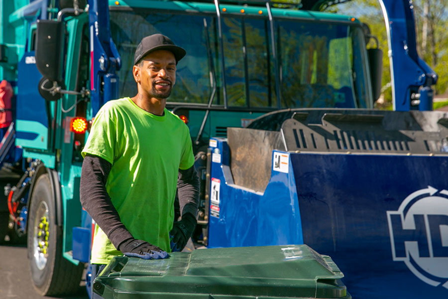 residential service driver with garbage cart and truck